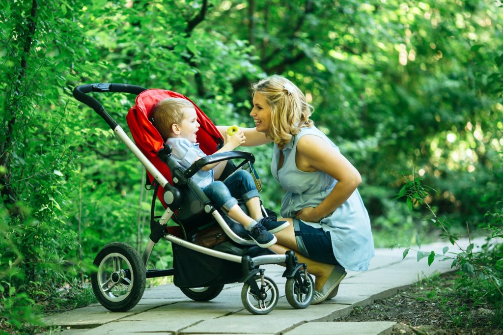 Pregnant woman with her child in pram